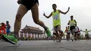 Peserta berlari melewati gerbang Tiananmen saat Beijing International Marathon di Beijing, China, Minggu (20/9/2015). Sekitar 30.000 pelari ikut ambil bagian dalam acara yang berlangsung tiap tahun. (REUTERS/Kim Kyung-Hoon)