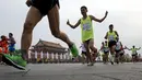 Peserta berlari melewati gerbang Tiananmen saat Beijing International Marathon di Beijing, China, Minggu (20/9/2015). Sekitar 30.000 pelari ikut ambil bagian dalam acara yang berlangsung tiap tahun. (REUTERS/Kim Kyung-Hoon)