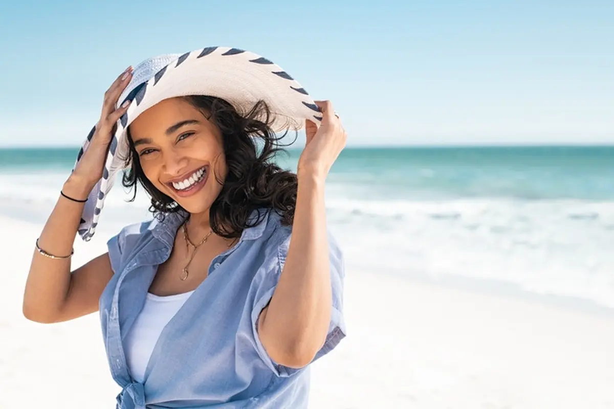 perempuan di pantai liburan tersenyum cantik