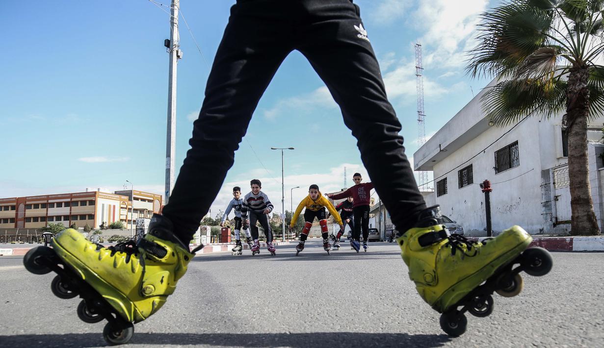Pemuda Palestina melakukan gaya bebas saat bermain sepatu roda dijalanan kawasan Khan Younis, Jalur Gaza, Selasa (19/1/2021). (AFP/Said Khatib)