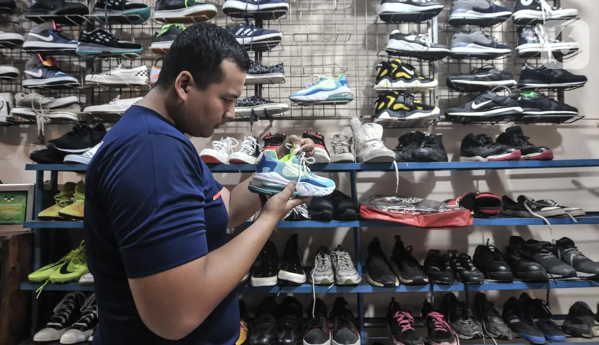 Calon pembeli saat melihat koleksi sepatu impor bekas di toko Second BJR, Kali Baru Timur, Cilincing, Jakarta Utara, Rabu (1/6/2022). Salah satunya adalah toko milik Bajuri yang telah berdiri sejak 2017, menjual berbagai jenis sepatu bermerek yang didapat dari luar negeri. (merdeka.com/Iqbal S. Nugroho)