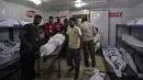 Relawan memindahkan tubuh salah satu jenazah korban gelombang panas usai diidentifikasi, di sebuah kamar mayat di Karachi, Pakistan, Senin (22/6/2015). (REUTERS/Akhtar Soomro)