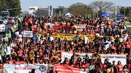 Perempuan pribumi berjalan kaki saat menggelar protes terkait kebijakan Presiden Brasil Jair Bolsonaro di Brasilia, Selasa (13/8/2019). Demonstrasi diikuti sekitar 3.000 perempuan pribumi dari seluruh Brasil. (EVARISTO SA/AFP)