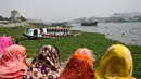 Orang-orang menonton feri yang diselamatkan setelah kecelakaan di Sungai Shitalakshya di Narayanganj, Bangladesh (21/3/2022). Setidaknya enam mayat ditemukan dan 20 orang masih hilang setelah sebuah feri terbalik di sungai Shitalakkhya. (AFP/Munir uz Zaman)