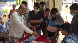 Keluarga korban kecelakaan kereta api paling mematikan di India dalam beberapa dekade terakhir memenuhi rumah sakit di kota Bhubaneswar pada hari Senin (5/6) untuk mencoba mengidentifikasi jasad kerabat mereka. (AP Photo/Rafiq Maqbool)