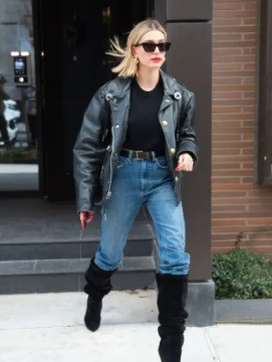 Di sini, Hailey Bieber mengenakan mom jeans dengan gaya tucked in yang sedang tren. Ia menyelipkan high-waisted mom jeansnya ke dalam sepatu boots hitam yang longgar. Foto: Instagram.