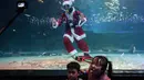 Ekspresi anak-anak saat menyaksikan penyelam berpakaian Sinterklas tampil dalam pertunjukan bawah laut bertema Natal di Akuarium COEX, Seoul, Korea Selatan, Jumat (7/12). (Ed JONES/AFP)