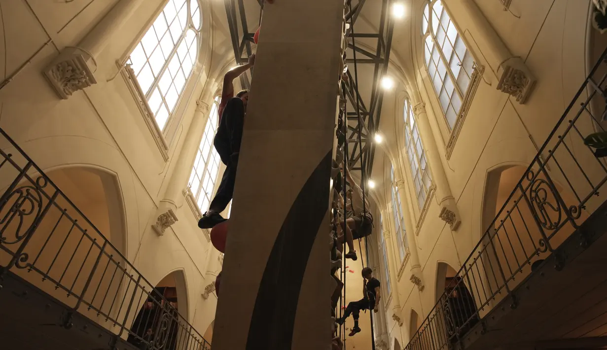 Peserta berlatih memanjat di lokasi Climbing District di Paris, Rabu, 11 Januari 2023. Tembok panjat buatan baru ini dibuka pada November 2022 di dalam bekas kapel abad ke-19, bernama le couvent des Oblats de Marie-Immaculee. (AP Photo/Christophe Ena)