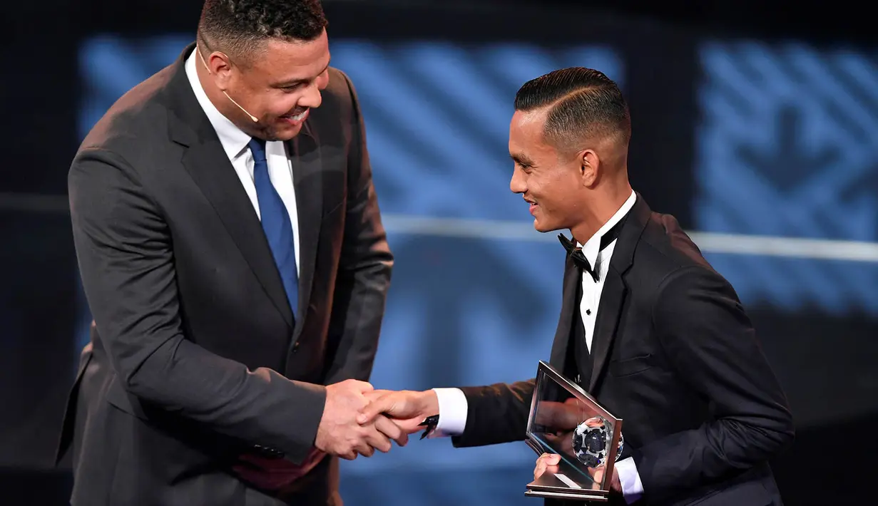 Pesepak bola Malaysia, Mohd Faiz Subri, menerima penghargaan FIFA Puskas Award 2016 yang diberikan oleh legenda hidup Brasil, Ronaldo. (AFP/Fabrice Coffrini)