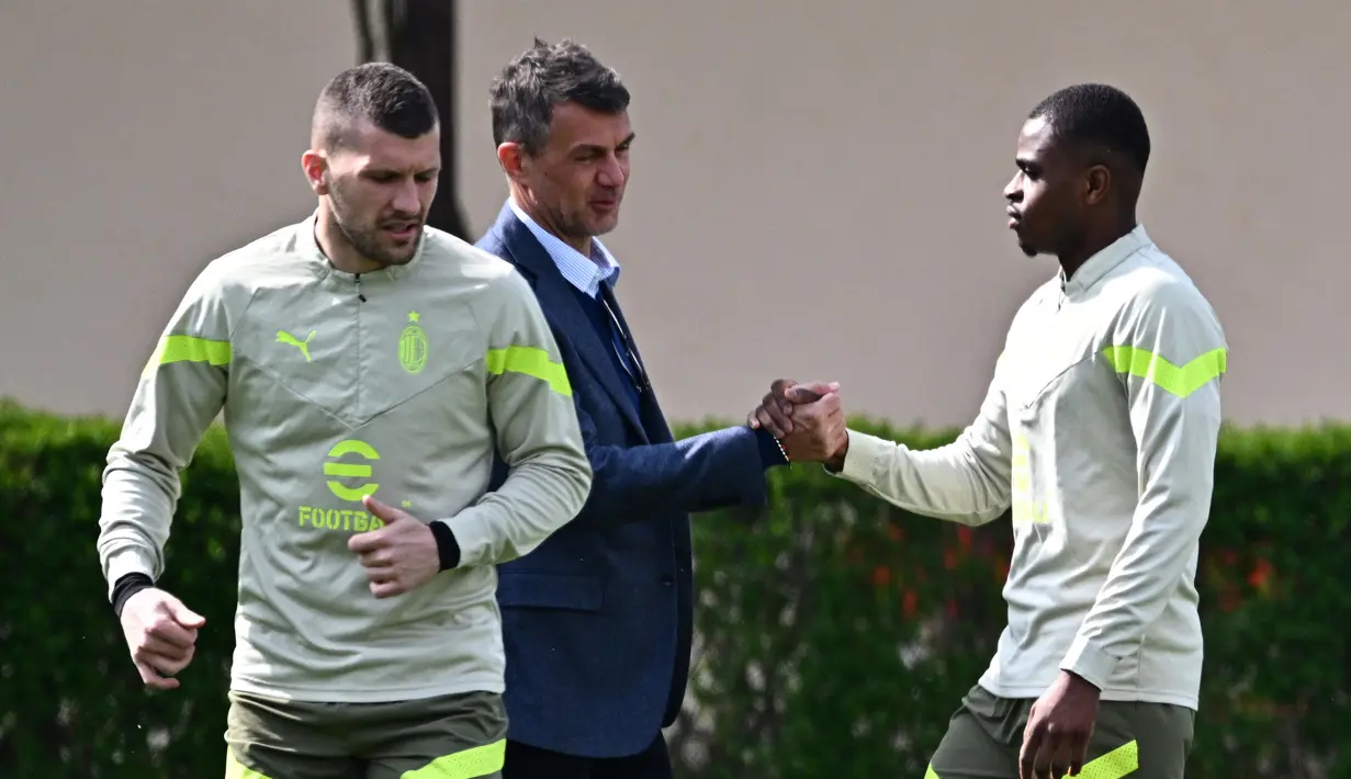 Direktur Teknik AC Milan, Paolo Maldini menyapa Pierre Kalulu (kanan) saat memantau langsung latihan jelang pertandingan leg pertama perempat final Liga Champions 2022/2023 antara AC Milan melawan Napoli yang berlangsung di Milanello training center, Carnago, Milan, Selasa (11/4/2023). (AFP/Gabriel Bouys)