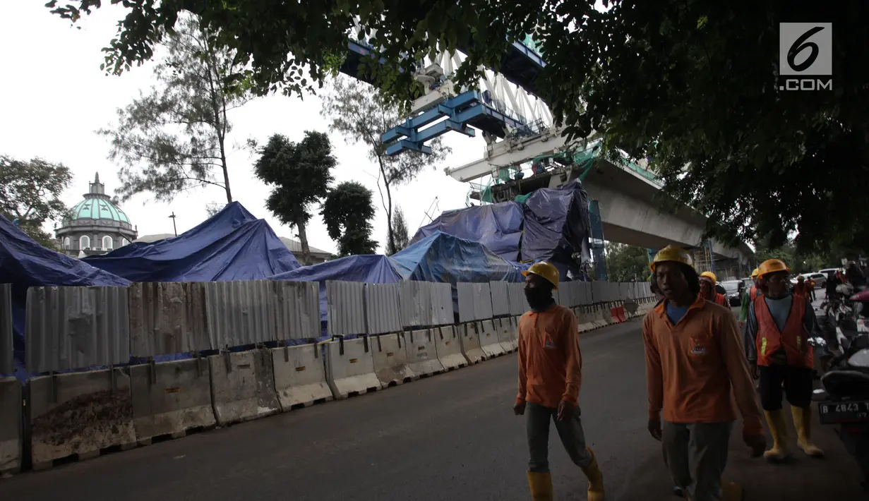 Pekerja melintas dekat kontruksi beton proyek light rapid transit ( LRT)  yang roboh di Kayu Putih, Jakarta Timur, Senin (22/1). Akibat robohnya konstruksi beton proyek LRT ini setidaknya lima orang yang mengalami luka-luka. (Liputan6.com/Arya Manggala)