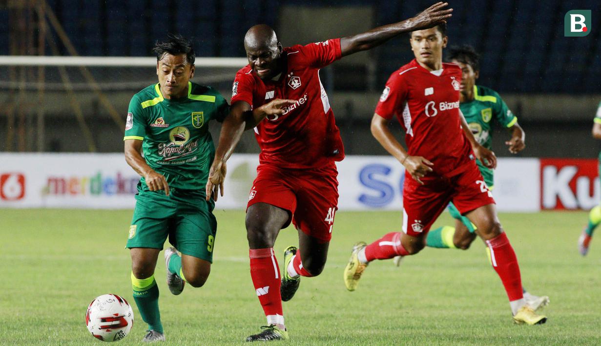 Striker Persebaya Surabaya, Samsul Arif (kiri) berebut bola dengan bek Persik Kediri, OK John dalam laga Grup C Piala Menpora 2021 di Stadion Si Jalak Harupat, Bandung, Selasa (23/3/2021). (Bola.com/M Iqbal Ichsan)