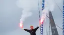 Pelaut Prancis, Francois Gabart menyalakan flare di atas kapal Macif saat merayakan rekor dunianya di pelabuhan Brest, Minggu (17/12). Gabart melintasi garis finis di bagian barat batas perairan Inggris dan Prancis pada Minggu pagi. (AP/Thibault Camus)