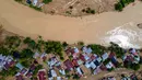 Permukiman warga nyaris tenggelam tidak terlihat lagi akibat terendam banjir. Tampak foto udara menunjukkan rumah-rumah warga yang rusak akibat banjir bandang di Meureudu, Kabupaten Pidie Jaya, provinsi Aceh, pada Jumat 28 November 2025. (CHAIDEER MAHYUDDIN/AFP)