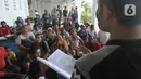 Puluhan warga duduk di pelataran rusun sambil melakukan mediasi dengan berbagai pihak, baik kuasa hukum, pihak kepolisian, dan lainnya. (merdeka.com/Imam Buhori)