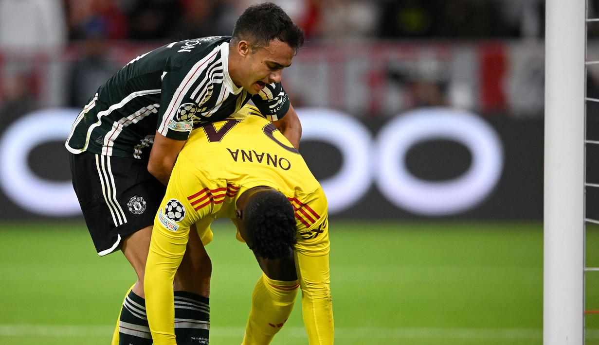 Pemain Manchester United, Sergio Reguilon (kiri) membangunkan kiper Andre Onana setelah kebobolan pada laga Grup A Liga Champions 2023/2024 melawan Bayern Munchen di Allianz Arena, Munchen, Jerman, 20 September 2023. (AFP/Tobias Schwarz)