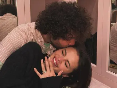 Pada unggahan Instagram, Selena membagikan foto dirinya bersama Benny Blanco dengan cincin pertunangan yang berkilauan di jari manisnya. Para penggemar sudah heboh dengan kabar tersebut, tapi Taylor menambah keseruan dengan komentarnya, "Yes, I will be the flower girl." Respons Taylor ini langsung disambut dengan antusias oleh penggemar, yang membayangkan kehadirannya dalam pernikahan Selena sebagai gadis bunga yang tak terlupakan. (Liputan6.com/IG/@selenagomez)
