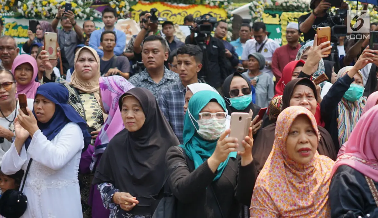 Warga memadati jalan di sekitar rumah duka Presiden ke-3 RI BJ Habibie di kawasan Kuningan, Jakarta, Kamis (12/9/2019). Meninggalnya BJ Habibie menarik simpatik masyarakat untuk datang mengantarkan kepergiaannya yang dimakamkan secara militer di TMP Kalibata, Jakarta Selatan. (Liputan6.com/Immanuel