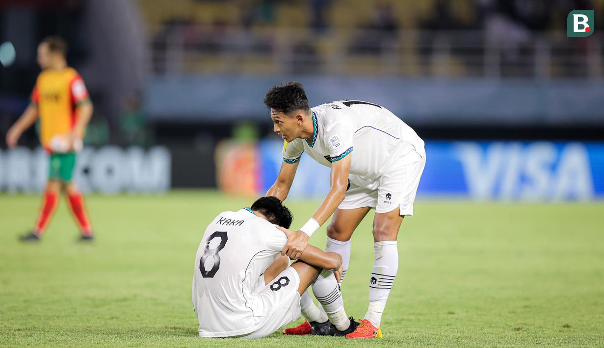 Pemain Timnas Indonesia U-17, Aulia Rahman (kanan) memberikan semangat kepada rekan satu timnya, Arkhan Kaka setelah dikalahkan Timnas Maroko U-17 dalam laga pamungkas Grup A Piala Dunia U-17 2023 yang berlangsung di Stadion Gelora Bung Tomo, Surabaya, Kamis (16/11/2023). (Bola.com/Bagaskara Lazuardi)