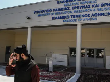 Seorang Muslim berdiri di luar bangunan masjid resmi pertama di Kota Athena, Yunani pada Jumat (7/6/2019). Masjid tersebut akan siap digunakan untuk beribadah puluhan ribu umat Muslim di Athena setelah melalui proses pembangunan selama lebih dari satu dekade. (Aris MESSINIS / AFP)