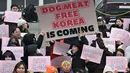 Para aktivis hak-hak hewan memegang plakat bertuliskan "Selamat tinggal daging anjing!" di Majelis Nasional di Seoul pada tanggal 9 Januari 2024. (JUNG YEON-JE/AFP)