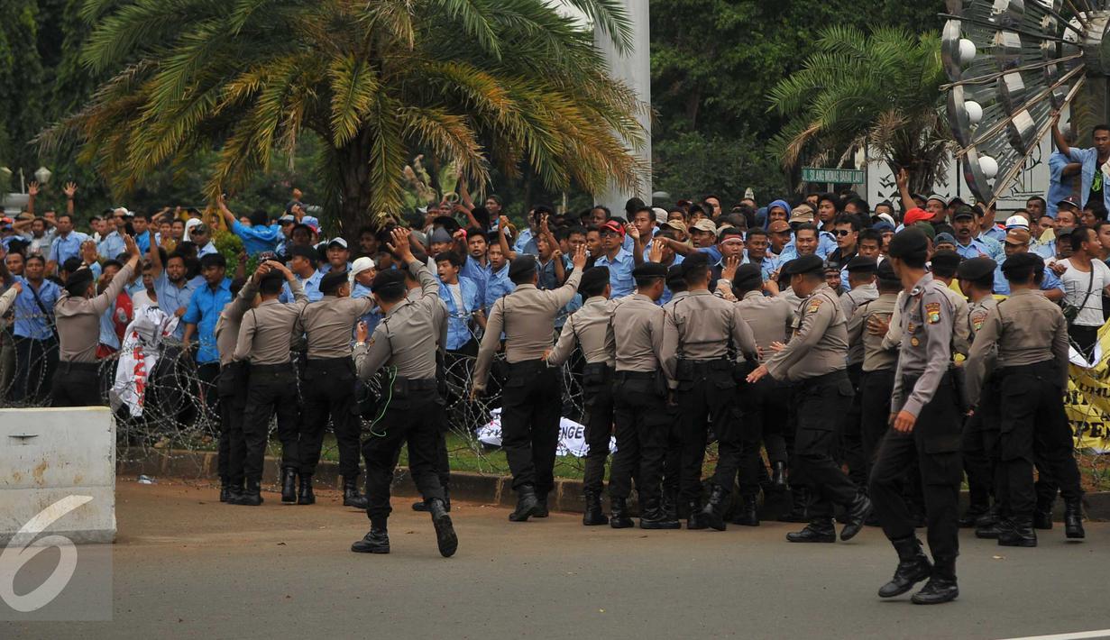 Petugas berusaha menenangkan sopir taksi yang melempar batu saat saat demo di depan Istana Negara, Jakarta, Selasa (22/3). Aksi lempar batu itu pecah saat pengunjuk rasa mendapat ejekan dari pengemudi ojek online. (Liputan6.com/Gempur M Surya)