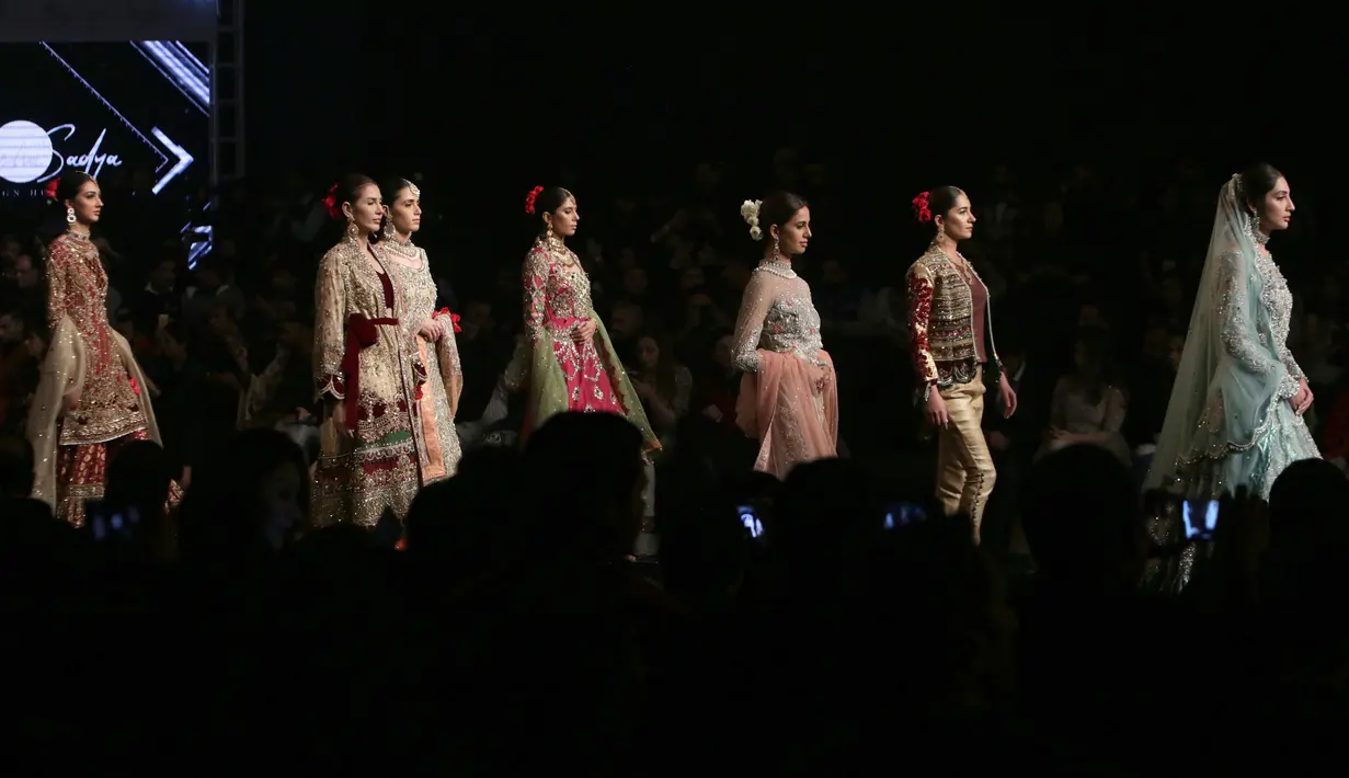 Model berjalan di runway membawakan busana rancangan desainer Aisha Sadya Design House selama Bridal Couture Week di Lahore, Minggu (9/12). Mereka memperagakan kreasi gaun pengantin dari sejumlah desainer ternama di Pakistan. (AP Photo/K.M. Chaudary)