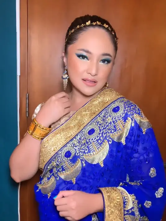 Marshanda memilih mengenakan sari India warna biru dengan bordiran warna keemasan serasi dengan innernya. Ia lengkap mengenakan aksesori gelang, anting, dan hiasan kepala. [@neny_mulyani]