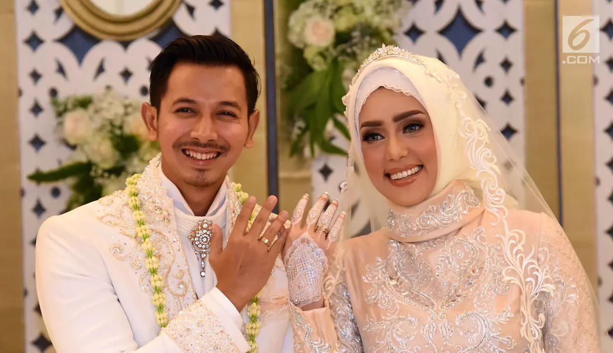 Pasangan Fairuz A Rafiq dan Sonny Septian menunjukan cincin kawin usai melangsungkan akad nikah di kawasan Kuningan, Jakarta Selatan, Minggu (21/5). Sonny memberi mahar unik berupa uang tunai Rp 999.999. (Liputan6.com/Herman Zakharia)