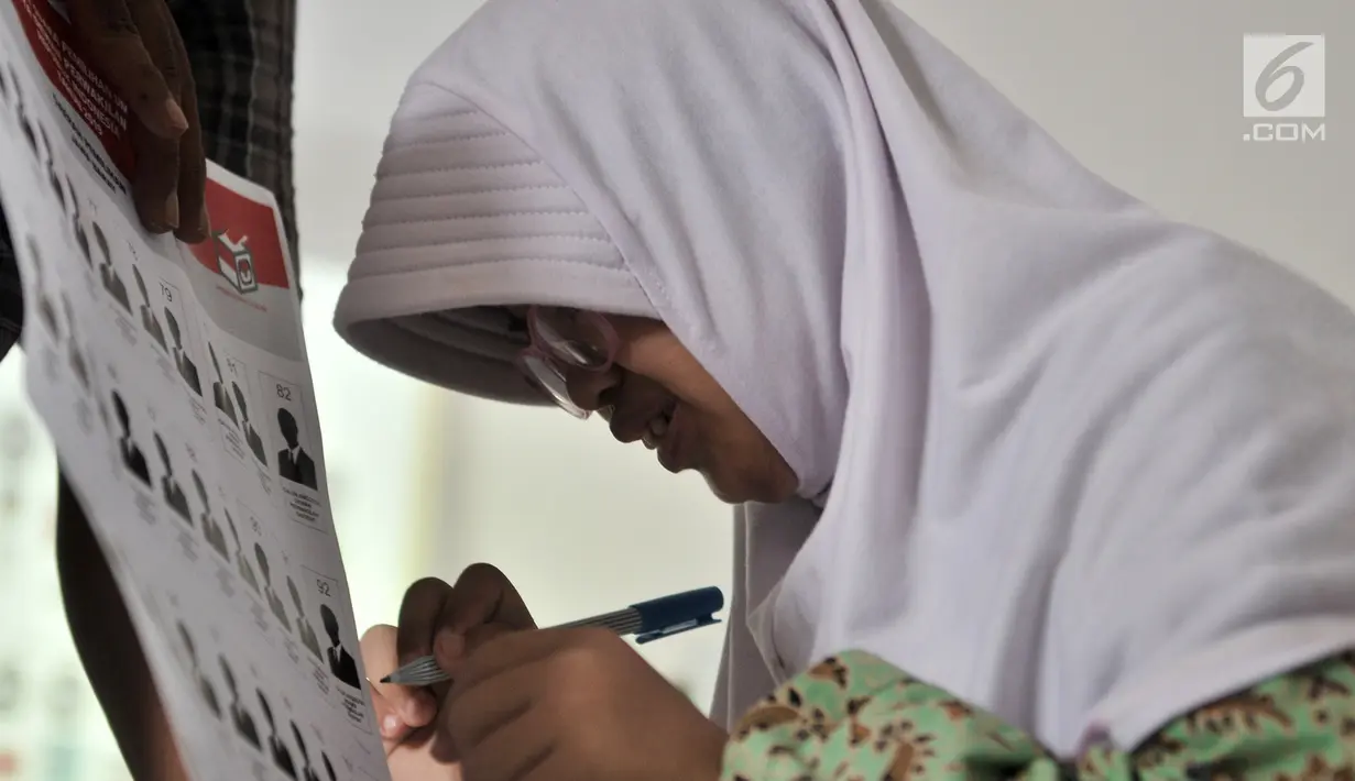 Pemilih pemula penyandang disabilitas mencoba mencoblos surat suara saat KPUD Bekasi menggelar sosialisasi Pemilu 2019 di SLB Al Gaffar Guchany, Bekasi, Rabu (20/2). (Merdeka.com/Iqbal Nugroho)