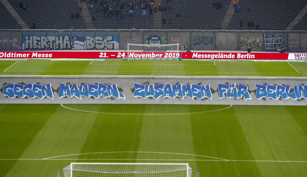 Replika Tembok Berlin bertuliskan "Bersatu menentang tembok.Bersatu untuk Berlin" berdiri jelang pertandingan Hertha Berlin melawan RB Leipzig di Stadion Olimpiade, Berlin (9/11/2019). Replika Tembok Berlin berdiri untuk memperingati 30 tahun keruntuhan serta bersatunya Jerman. (AFP/Odd Andersen)