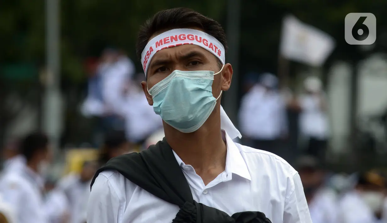Massa Asosiasi Pemerintah Desa Seluruh Indonesia (Apdesi) saat melakukan unjuk rasa di kawasan Silang Monas, Jakarta, Kamis (16/12/2021). Apdesi menuntut Presiden Joko Widodo merevisi Perpres Nomor 104 Tahun 2021 tentang Rincian APBN 2022. (merdeka.com/Imam Buhori)