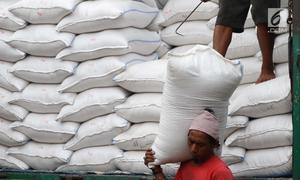 Seorang kuli angkut menurunkan beras dari atas truk di Pasar Induk Cipinang, Jakarta, Senin (25/9). Pedagang beras Cipinang sudah menerapkan dan menyediakan beras medium dan beras premium sesuai harga eceran tertinggi (HET). (Liputan6.com/Angga Yuniar)