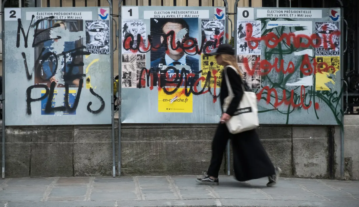 Poster salah satu Capres Prancis terkena aksi vandalisme di Paris, Selasa (2/5). Sejumlah poster capres Prancis lainnya juga tampak rusak yang diduga dilakukan oleh orang yang tidak suka dengan mereka. (AFP PHOTO / JOEL SAGET)