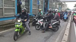 Sejumlah pengendara sepeda motor mencoba menghindar saat polisi menggelar razia bagi penerobos jalur Transjakarta di Jalan Sultan Agung, Manggarai, Jakarta, Rabu (12/2/2020). Pengendara kerap melintasi jalur Transjakarta untuk menghindari kemacetan lalu lintas. (Liputan6.com/Herman Zakharia)