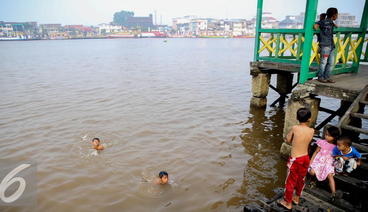Sejumlah anak – anak berenang dan bermain di Sungai Kapuas, Pontianak, Kalimantan Barat, Sabtu (22/8/2015). Anak-anak yang tinggal sekitar Sungai Kapuas biasa mandi dan berenang di aliran tersebut setiap pagi dan sore hari. (Liputan6.com/Faizal Fanani)