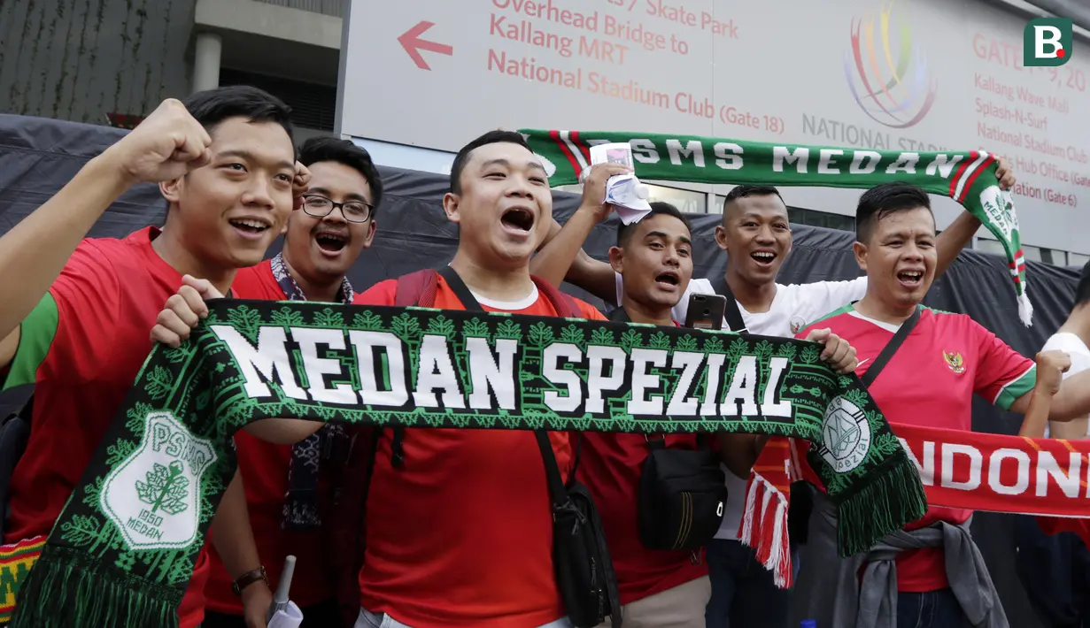 Suporter Timnas Indonesia menyanyikan lagu saat berada di Stadion Nasional, Singapura, Jumat (9/11). Indonesia akan melawan Singapura pada laga Piala AFF 2018. (Bola.com/M. Iqbal Ichsan)