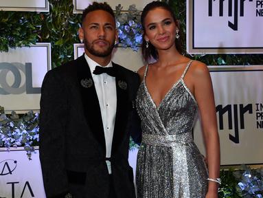 Pemain PSG, Neymar, didampingi sang kekasih, Bruna Marquezine, saat menghadiri acara amal untuk Institut Neymar Jr di Sao Paulo, Brasil, Kamis (19/7/2018). Bintang asal Brasil itu tampak menawan dengan balutan jas. (AFP/Nelson Almeida)