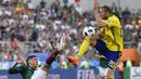 Pemain Meksiko, Edson Alvarez (kiri) menghalau bola dari kejaran pemain Swedia, Ola Toivonen pada laga grup F Piala Dunia 2018 di Yekaterinburg Arena, Yekaterinburg, Rusia, (27/6/2018).  Swedia menang telak 3-0 atas Meksiko. (AP/Martin Meissner)