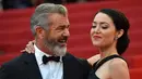 Aktor senior Mel Gibson tampak menatap sang kekasih, Rosalind Ross saat berpose di acara penutupan Festival Film Cannes, Prancis, 22 Mei 2016.  Seperti yang diketahui, usia Mel Gibson dan kekasih cantiknya terpaut 35 tahun. (A LOIC VENANCE/AFP)