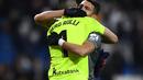 7. Kiper Sociedad, Geronimo Rulli berpelukan dengan Hector Moreno pada laga lanjutan La Liga Spanyol yang berlangsung di Stadion Santiago Bernabeu, Madrid, Senin (7/1). Real Sociedad menang 2-0 atas Real Madrid. (AFP/Gabriel Bouys)