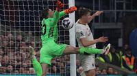 Striker Manchester United #11 Rasmus Hojlund melakukan pelanggaran terhadap kiper Crystal Palace #30 Dean Henderson (kiri) saat merebut bola yang menyebabkan gol tersebut dianulir pada laga pekan ke-36 Premier League 2023/2024 di Selhurst Park, Selasa (7/5/2024) dini hari WIB. (Adrian DENNIS / AFP)