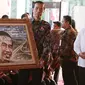 Presiden Jokowi bersama Menteri Koordinator bidang Perekonomian Darmin Nasution memegang karya foto yang bergambar wajahnya saat pameran hasil lomba foto pembangunan infrastruktur di Silang Monas, Jakarta, Minggu (27/8). (Liputan6.com/Angga Yuniar)