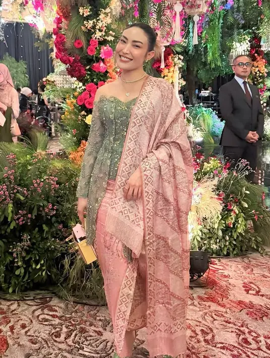 Artis Ayu Dewi juga hadir mengenakan kebaya hijau brokat berpayet dipadukan selendang dan bawahan kain songket pink. Ia membawa mini bag Hermes dan mengenaka kalung layering. [@mrsayudewi]