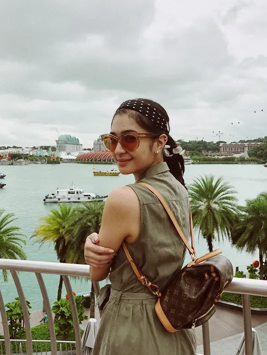 Simpel dan tetap stylish ala Mikha Tambayong juga bisa jadi inspirasi dalam berpakaian. Kali ini aktris sekaligus model itu tampil dengan terusan berwarna hijau army. Kacamata dan bandana yang dipakai membuat penampilannya semakin lengkap. (Liputan6.com/IG/@miktambayong)