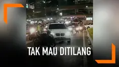 Sebuah mobil mewah tolak ditilang oleh petugas, pengemudi bahkan mencoba menabrak dan melarikan diri.