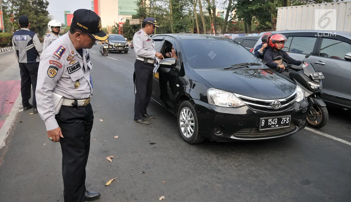 Petugas Dinas Perhubungan DKI Jakarta melakukan sosialisasi uji coba perluasan sistem ganjil genap kepada pengendara di kawasan Pramuka, Jakarta, Senin (12/8/2019). Dinas Perhubungan DKI Jakarta melakukan uji coba perluasan sistem ganjil genap hingga 6 September 2019. (merdeka.com/Iqbal Nugroho)