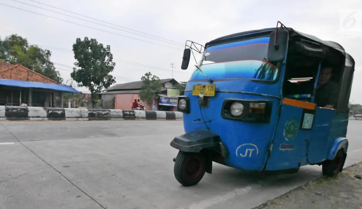 Pemudik bersama keluarganya menggunakan bajaj saat perjalanan mudik melintasi Jalur Pantura kawasan Patrol, Jawa Barat, Senin (3/6/2019). Keluarga ini memanfaatkan bajajnya sebagai angkutan mudik dari Jakarta menuju kampung halamannya di Cirebon, Jawa Tengah. (Liputan6.com/Herman Zakharia)