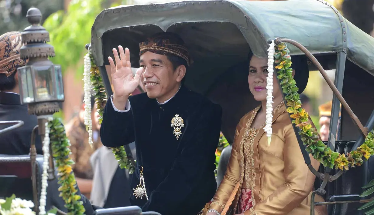 Dengan Kereta Kencana, rombongan keluarga besar Presiden Joko Widodo saat itu hendak menuju ke lokasi pernikahan Kahiyang dan Bobby di Graha Saba Buana. Lambaian tangan dan senyuman terus diberikan Jokowi. (Adrian Putra/Bintang.com)