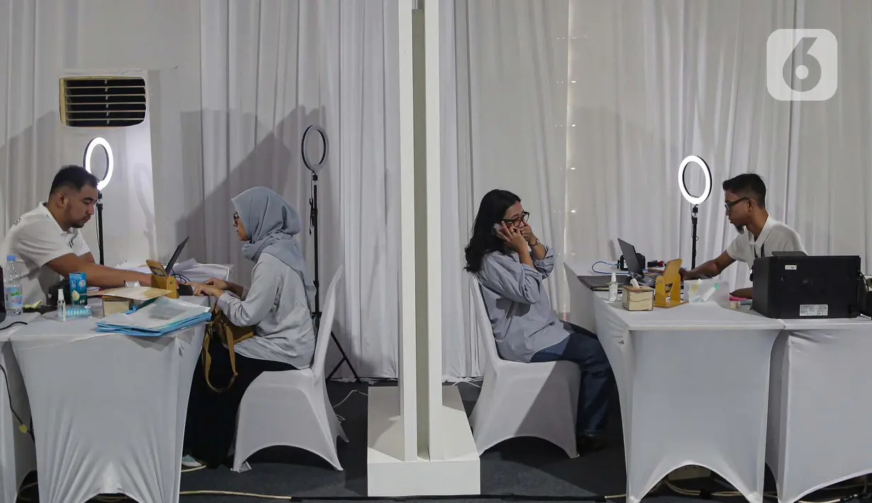 Petugas dari Direktorat Jenderal (Ditjen) Imigrasi melayani warga pemohon pembuatan paspor di Plaza Parkir Timur Kawasan Gelora Bung Karno (GBK), Jakarta, Minggu (19/1/2025). (Liputan6.com/Angga Yuniar)